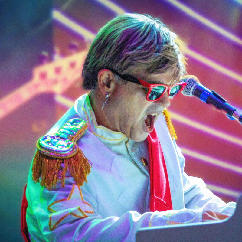 Maestro Rogério Martins usando óculos icônico de Elton John no show Rocket Man